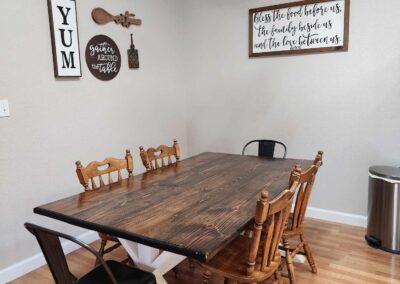 Dining room table with wooden chairs and wall decor
